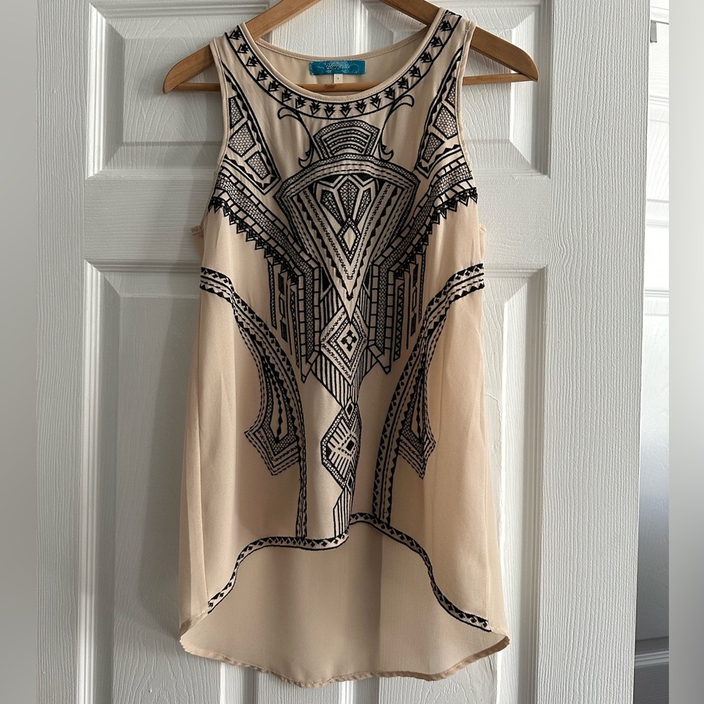 Stylish sleeveless top with intricate black embroidery